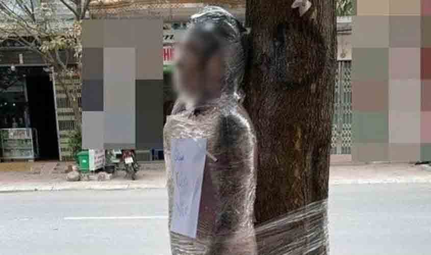 Homem é enrolado em árvore com plástico filme por não pagar tatuagem